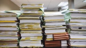 Pila de papeles ejemplificando licencias para abrir un negocio.